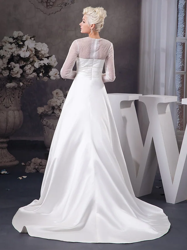 Close-up of the jewel neck and illusion sleeves on the wedding dress.