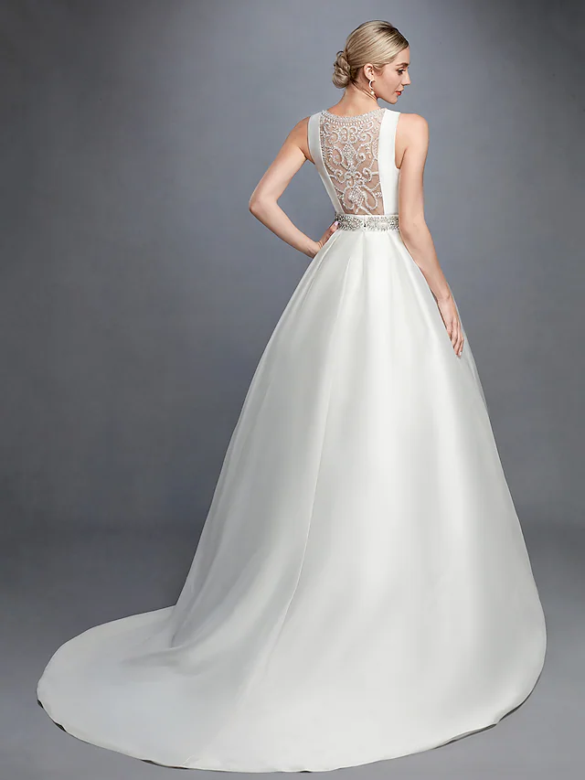 Side view of bride in white ball gown wedding dress with court train.