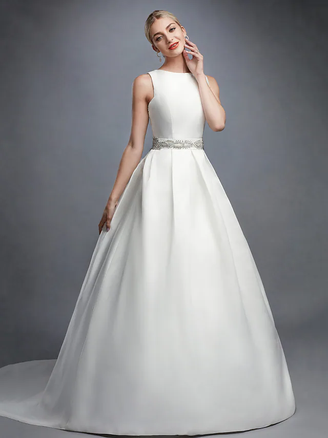 Bride posing in white ball gown wedding dress with regular straps.