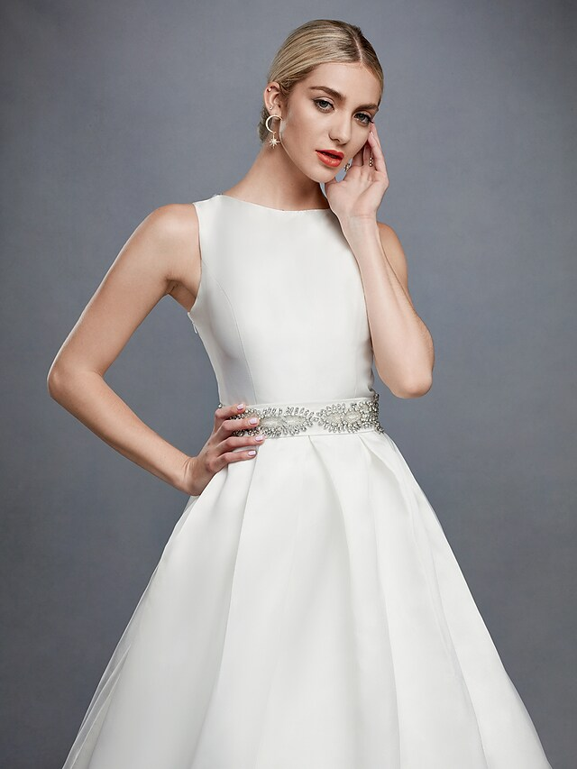 Elegant white bridal gown with intricate lace and beading.