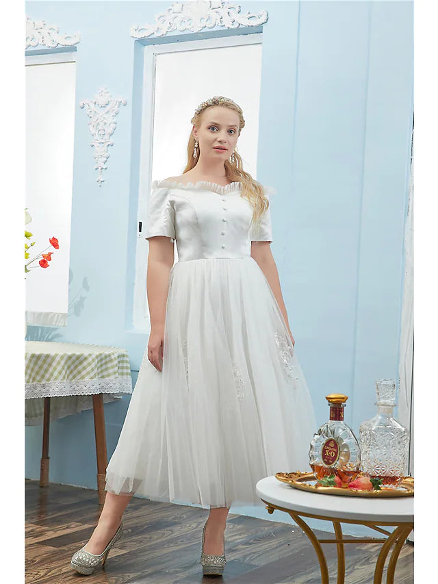 Elegant plus size off-shoulder tulle ball gown with short sleeves and button details.
