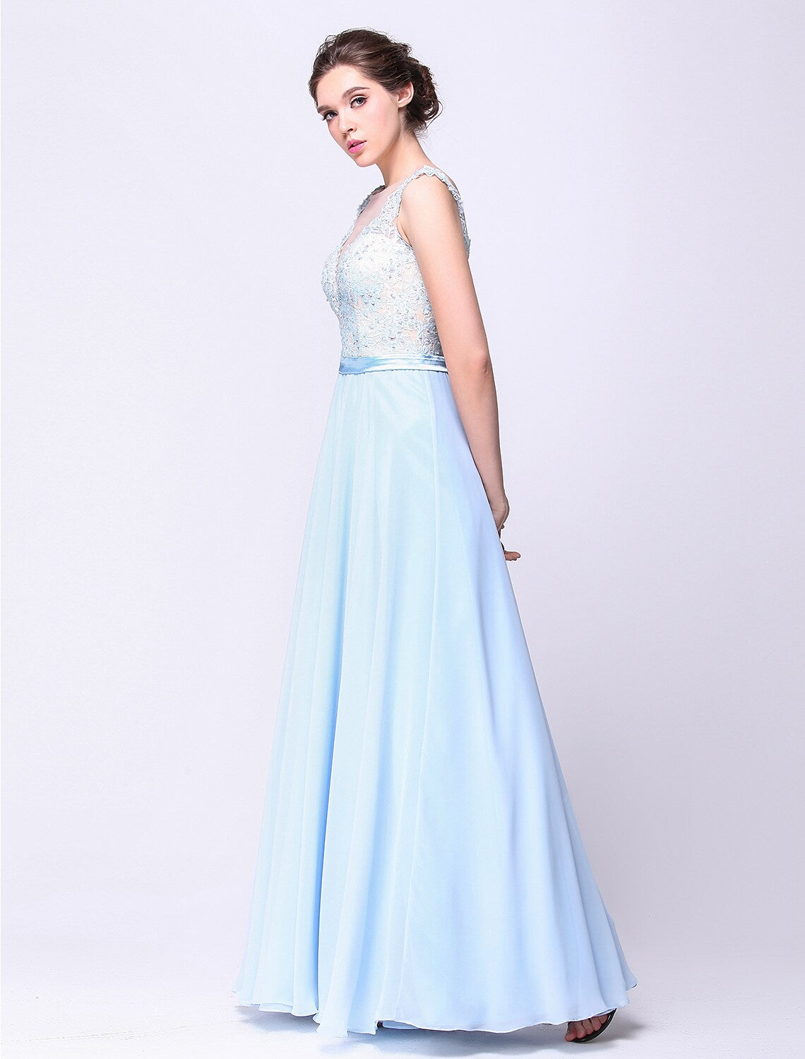 Model wearing an elegant floor-length ball gown with a plunging neckline and beading appliques.