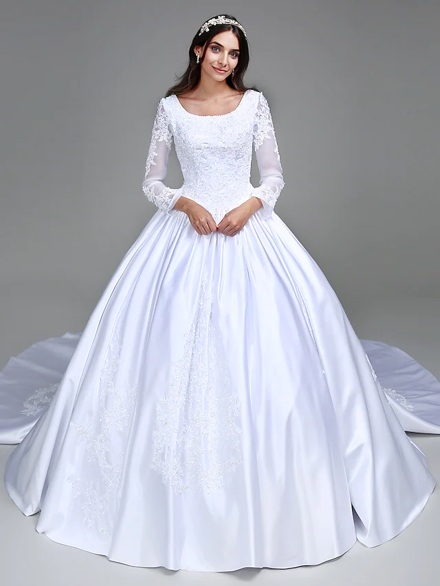Close-up of the scoop neck and long satin sleeves with beading appliques on the wedding dress.