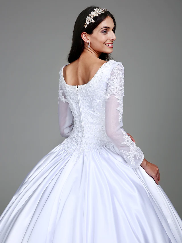 Elegant vintage wedding dress with a scoop neckline and flowing ball gown skirt.