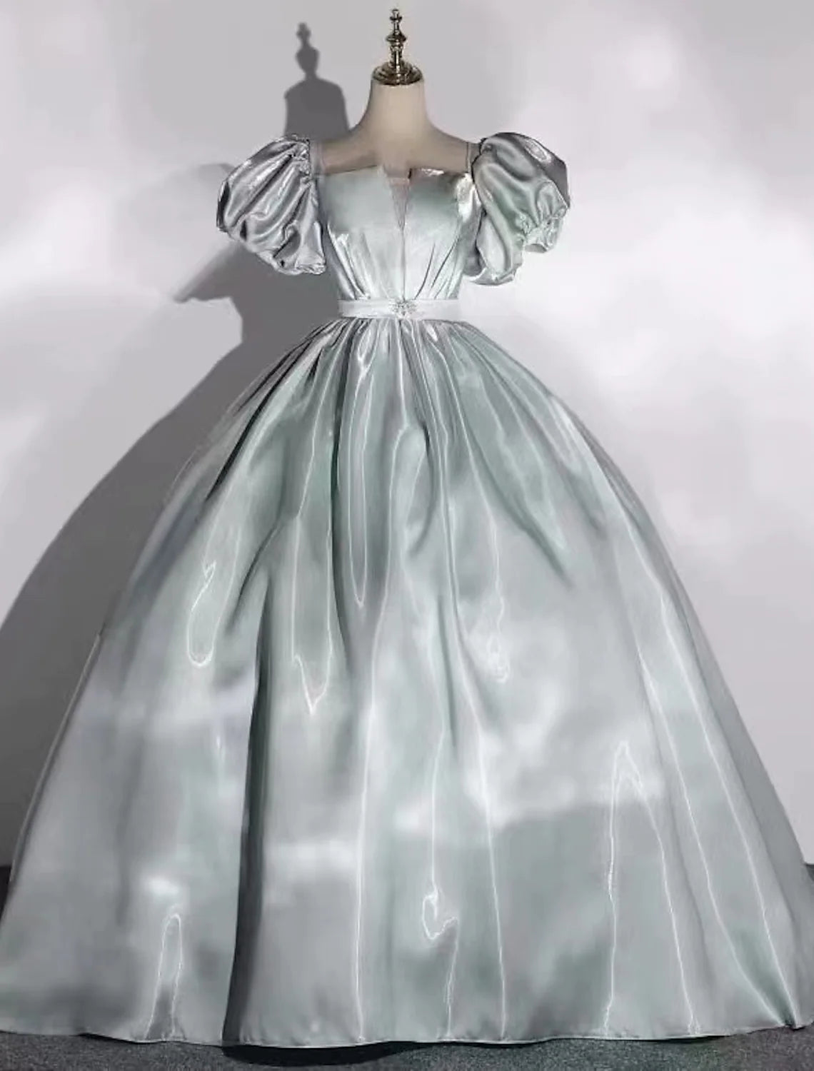 A radiant floor-length satin ball gown with a scoop neck and short sleeves.