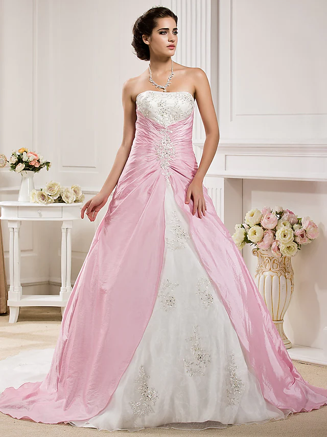 Elegant strapless ball gown wedding dress with ruched bodice and chapel train.