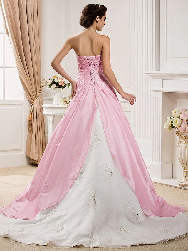 Back view of a strapless ball gown wedding dress with a long chapel train.