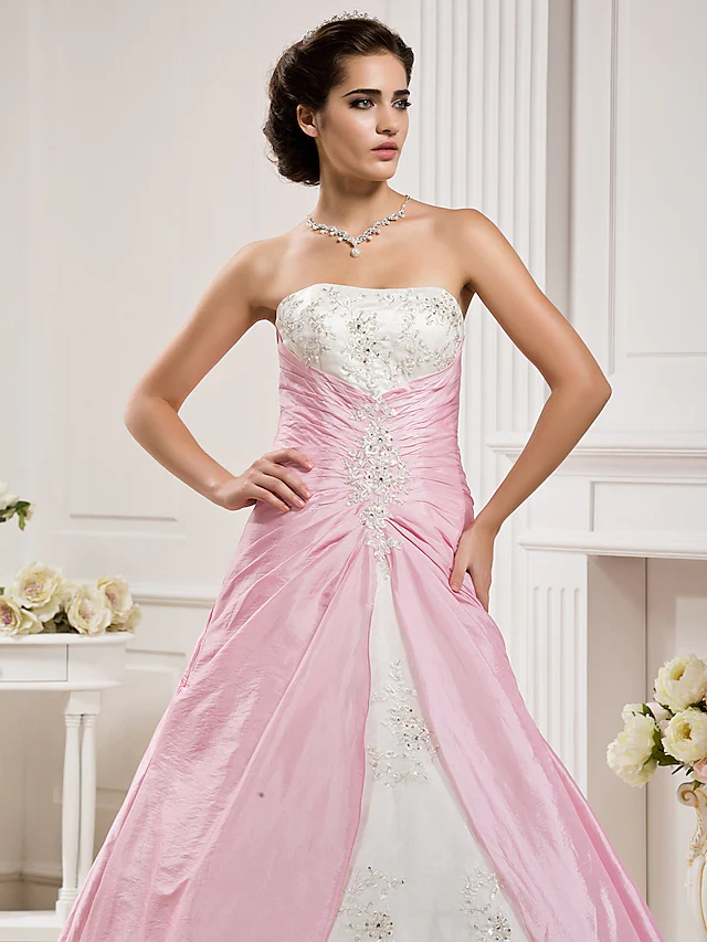 Close-up of the ruched bodice and beaded appliques on a wedding dress.