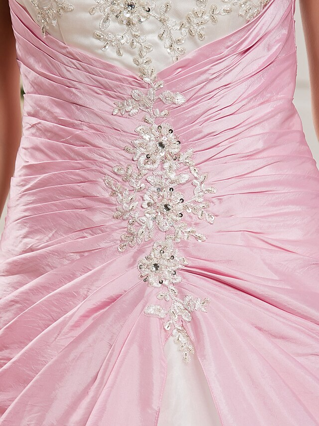 Front view of a strapless ball gown with intricate beading on the bodice.