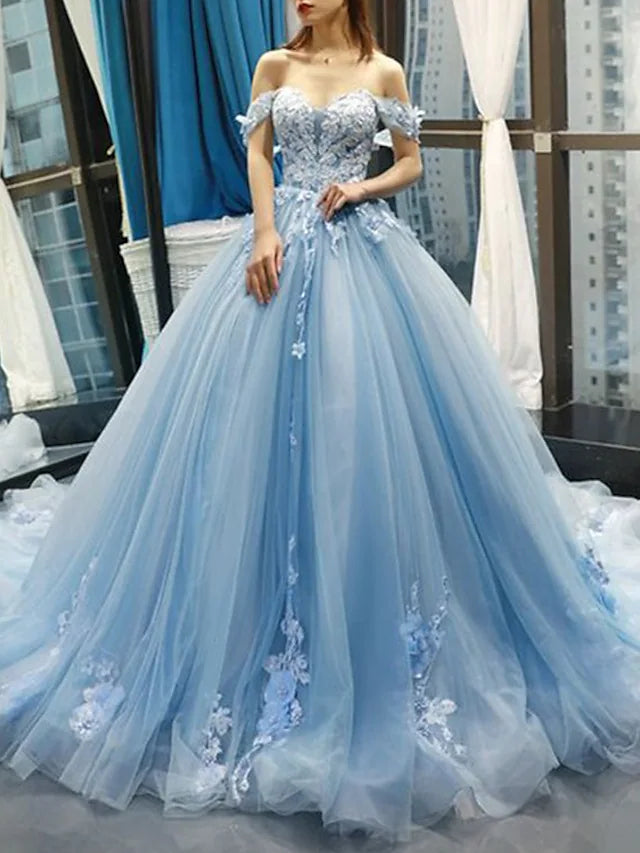 Side view of a floral lace ball gown quinceanera dress with a flowing court train.