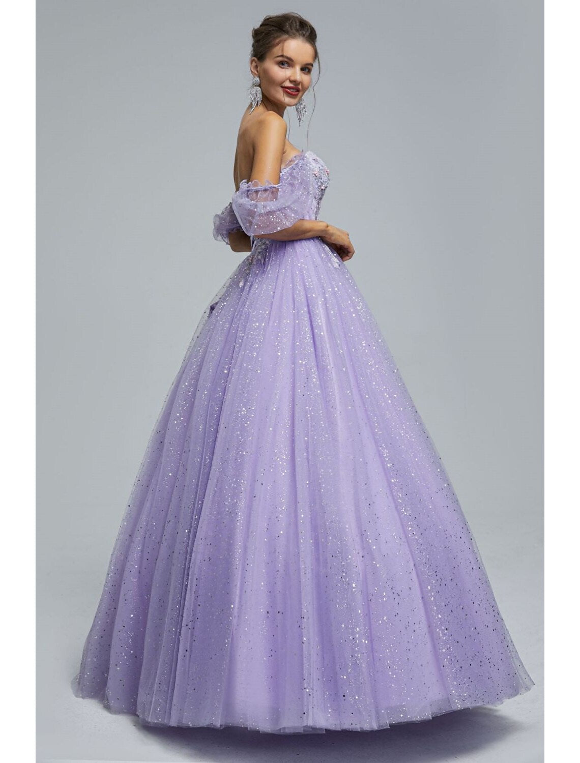Side view of floor-length tulle ball gown with sequin appliques.