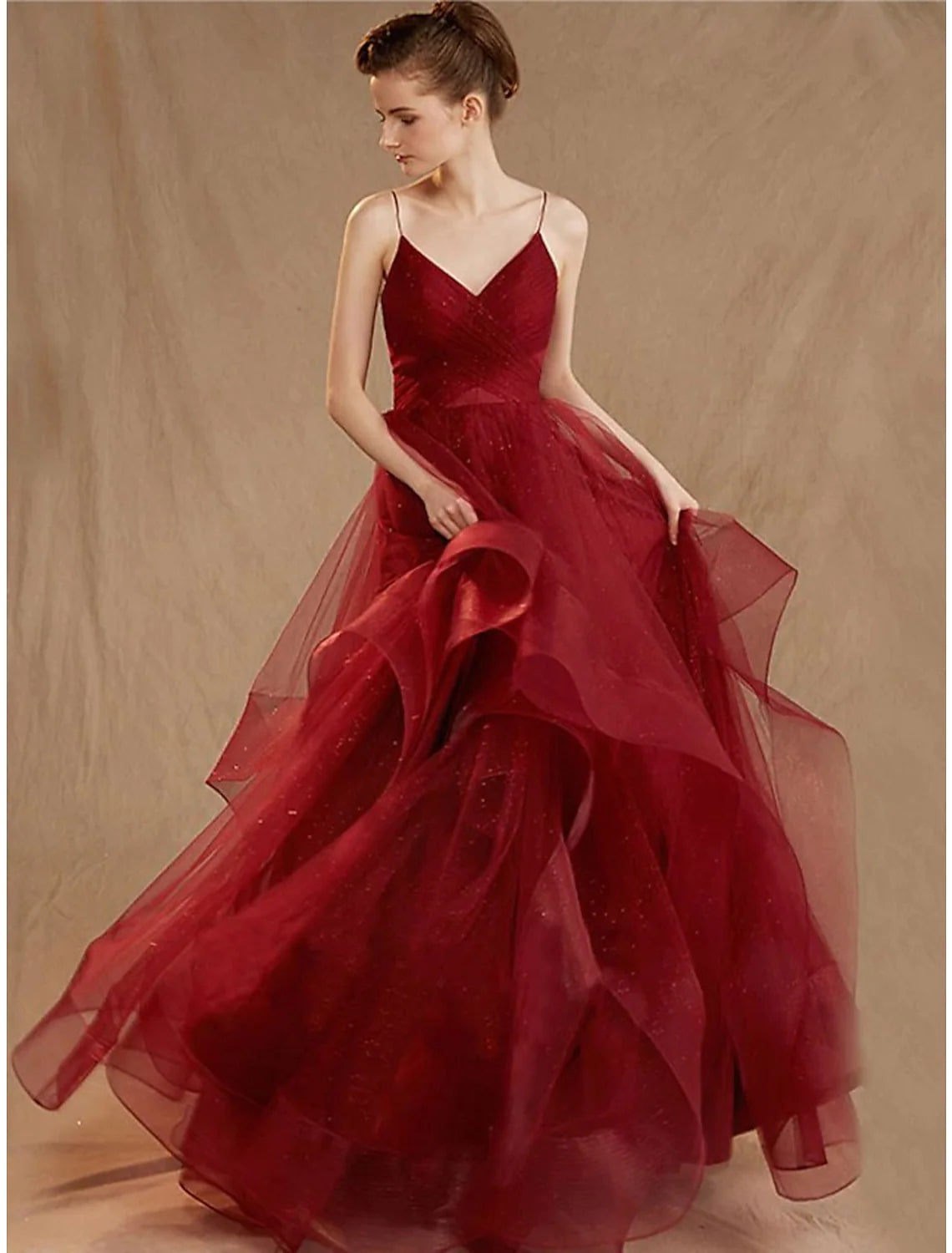 Back view of a floor-length tulle ball gown with sequin ruffles and V-back.