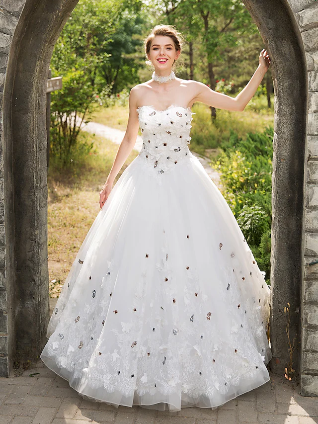 Elegant ball gown wedding dress with sweetheart neckline, lace appliques, and tulle skirt.