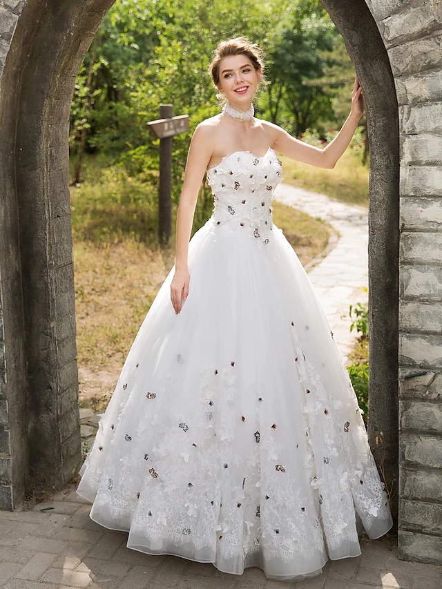 Side view of the sleeveless ball gown wedding dress with floral appliques.