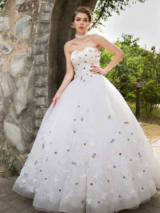 Flowing tulle skirt and lace appliques of the ball gown wedding dress.