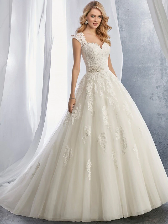 Close-up of sweetheart neckline and delicate lace appliques on wedding dress.