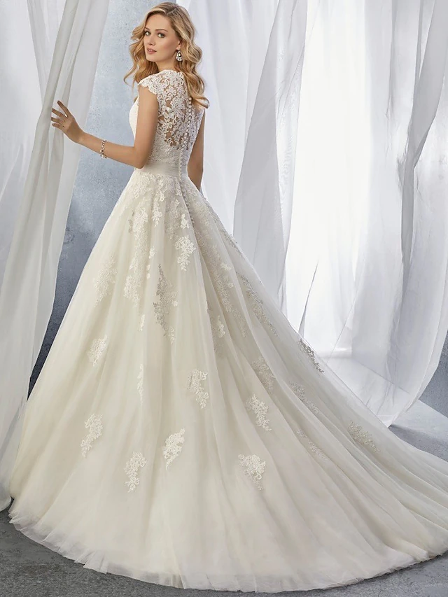 Side profile of ball gown wedding dress with regular straps and tulle skirt.