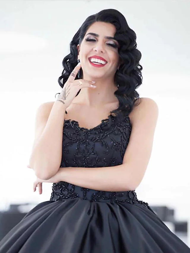 Side view of black satin ball gown with draping details.