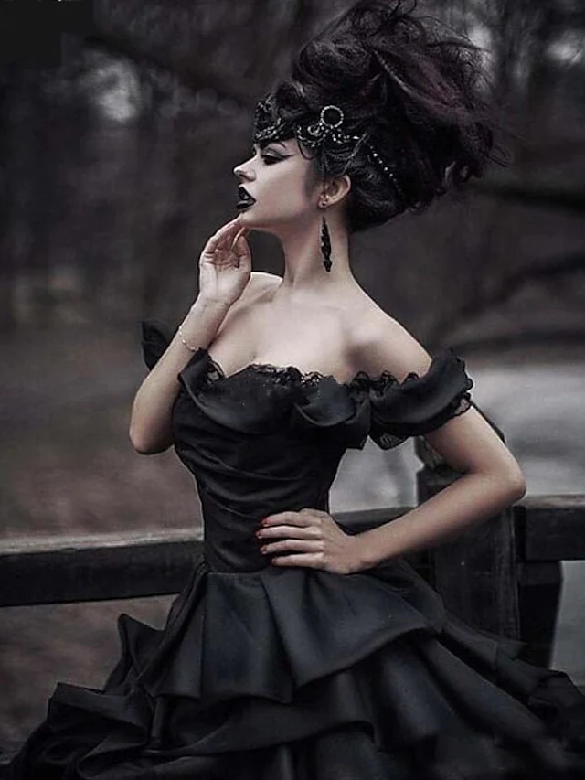 Close-up of lace detail on black off-shoulder wedding dress.