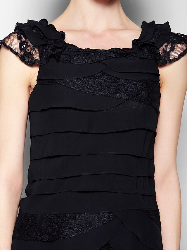 Black formal dress with scoop neck and sleeveless design, styled for an event.
