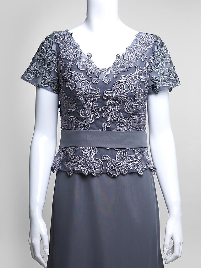 Close-up of the V-neckline and short lace sleeves on the elegant dress.
