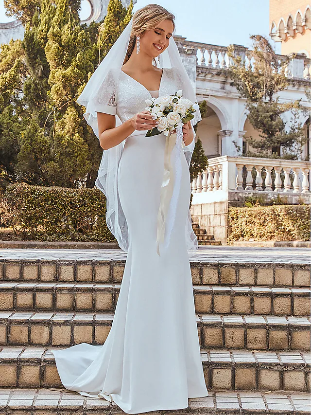 Back view of the romantic floor-length wedding dress showing delicate chiffon draping.