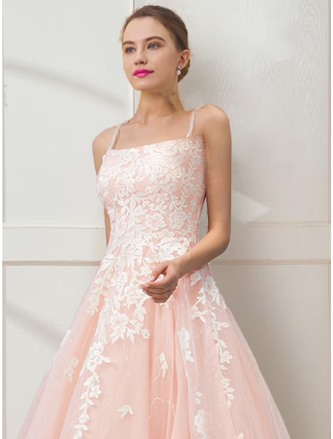 Back view of a floral ball gown prom dress showing crisscross spaghetti straps and embroidery.