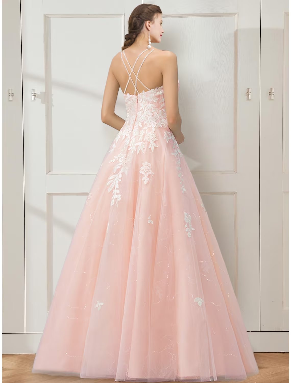 Close-up of the intricate floral embroidery detail on a light-colored ball gown prom dress.