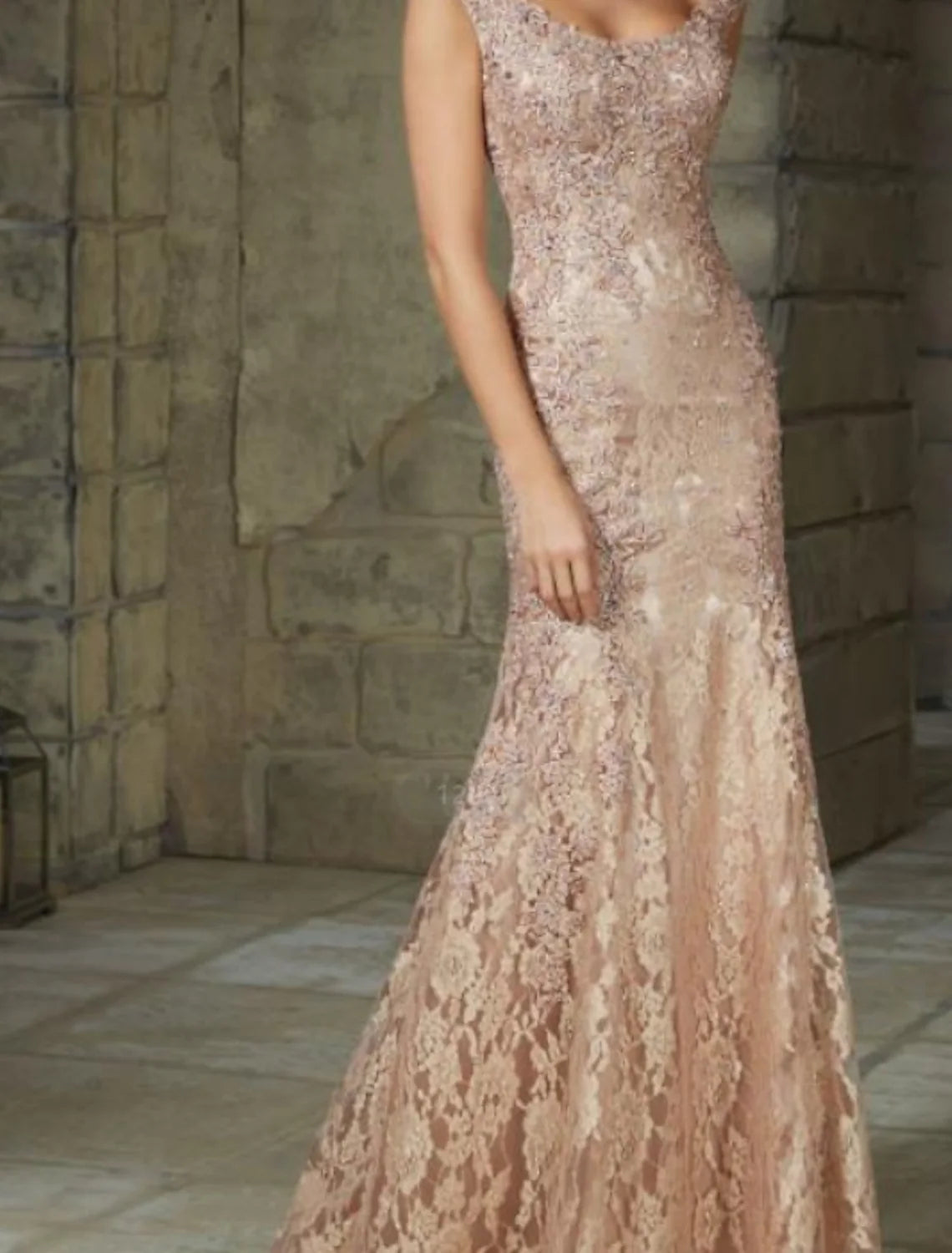 Back view of a woman in a sleeveless mermaid trumpet wedding guest dress.