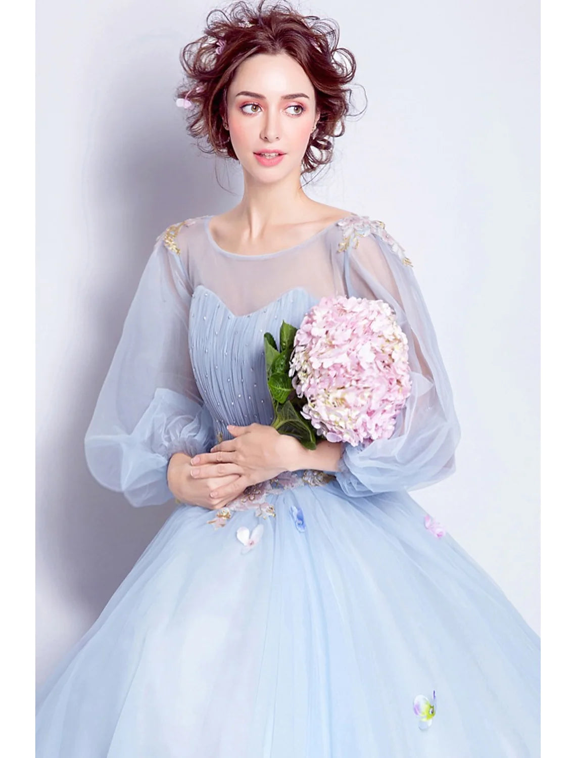 Back view of floral ball gown showing floor-length tulle skirt and appliques.