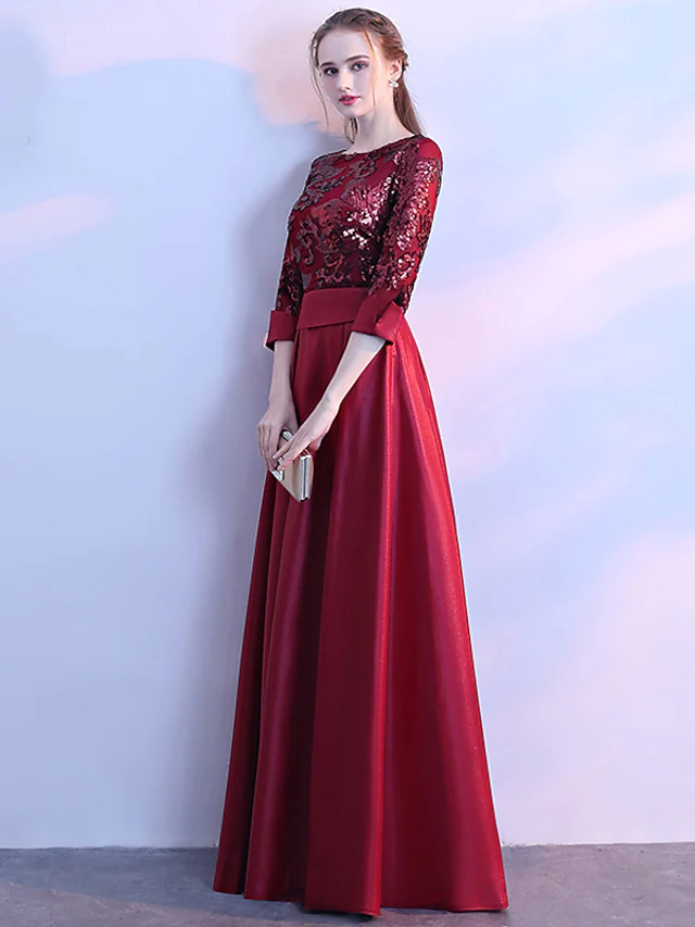 Elegant A-line glittering evening dress with jewel neck and 3/4 sleeves.