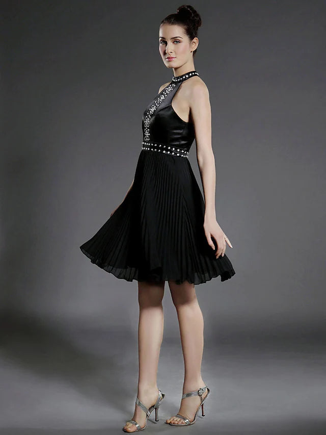 Close-up of black chiffon dress fabric with pleats and beading.