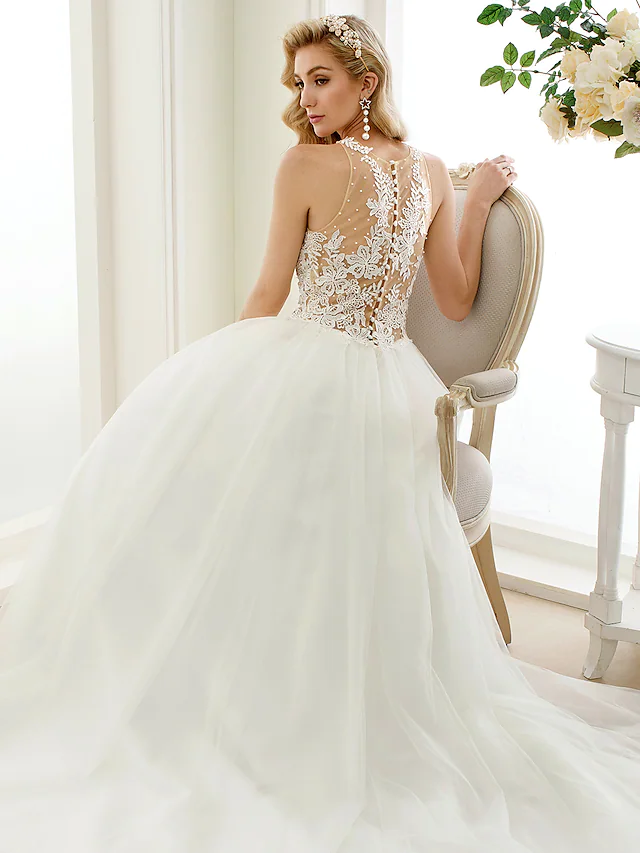 Side profile of a bride in a ball gown wedding dress with chapel train.