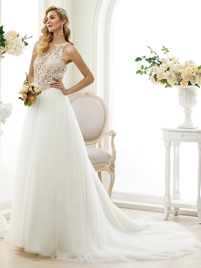 Full length view of a bride wearing a white ball gown wedding dress.