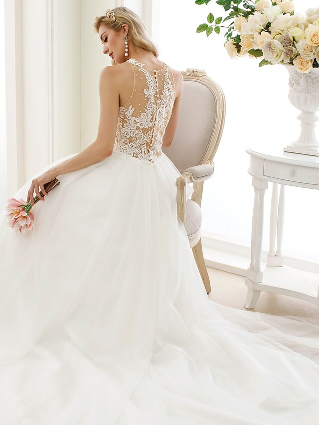 Bride posing in an elegant jewel neck ball gown wedding dress.
