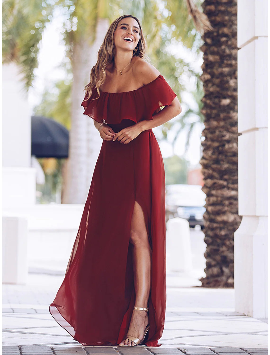 Woman wearing a black ruched U neck maxi party dress.