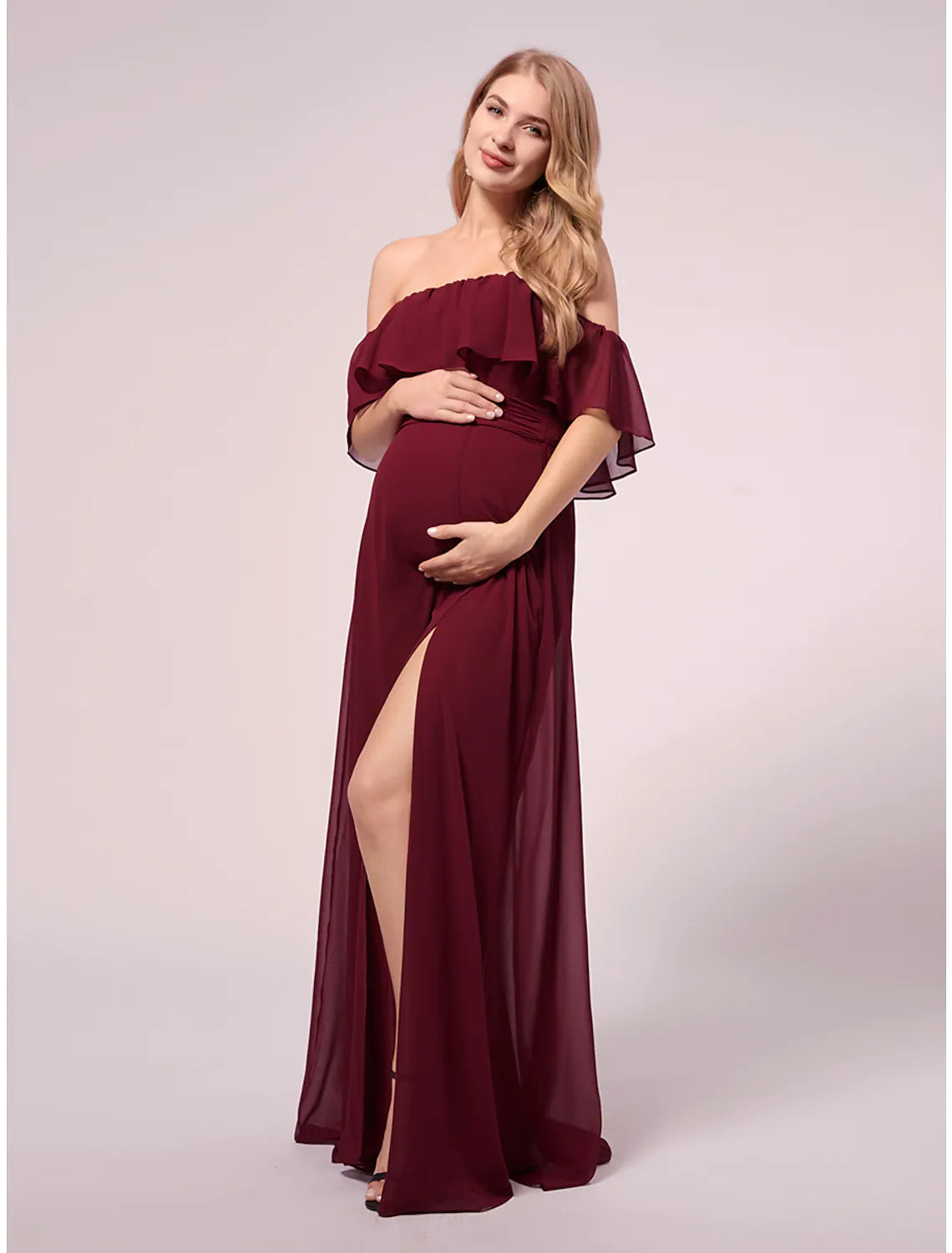 Woman wearing a blue ruched U neck maxi party dress.