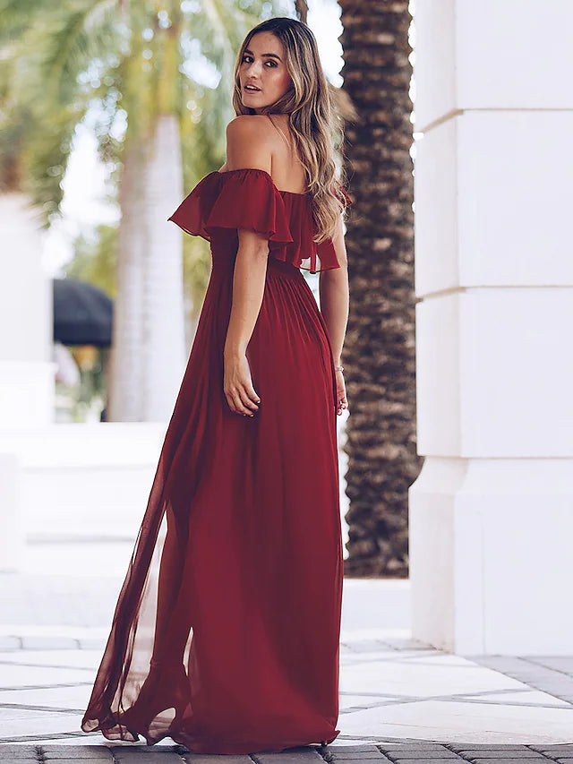 Woman wearing a purple ruched U neck maxi dress.
