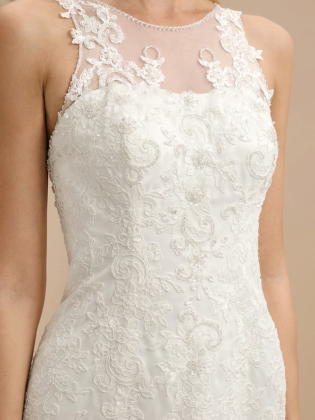 Bride posing in a backless lace wedding dress.