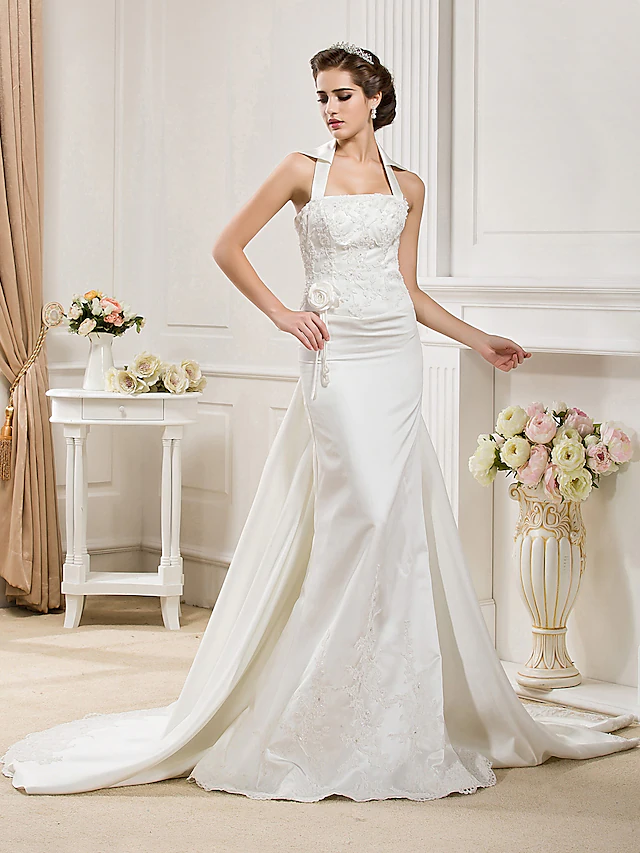 Bride in a white halter neck mermaid wedding dress with a court train.
