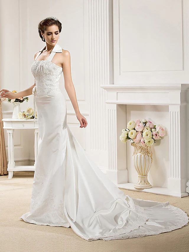 Back view of a bride in a white halter neck mermaid wedding dress, highlighting the court train.