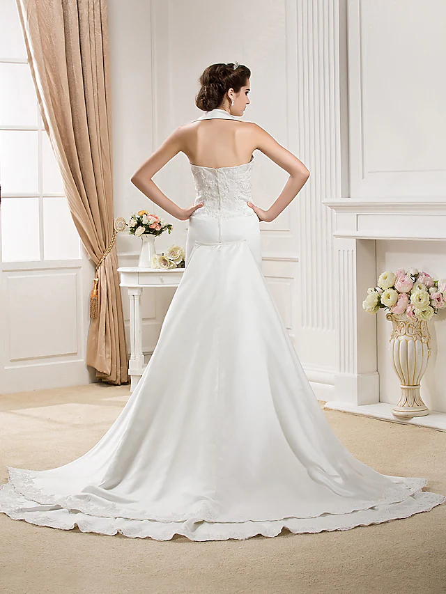 Close-up of the halter neckline and bodice of the white satin wedding dress.
