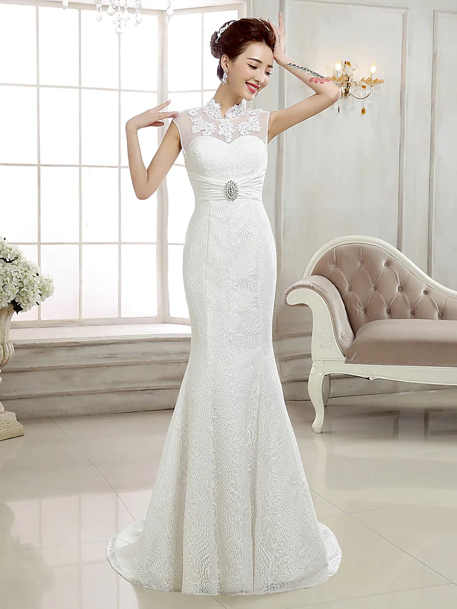Close-up of intricate lace and beading appliques on a high neck wedding gown.