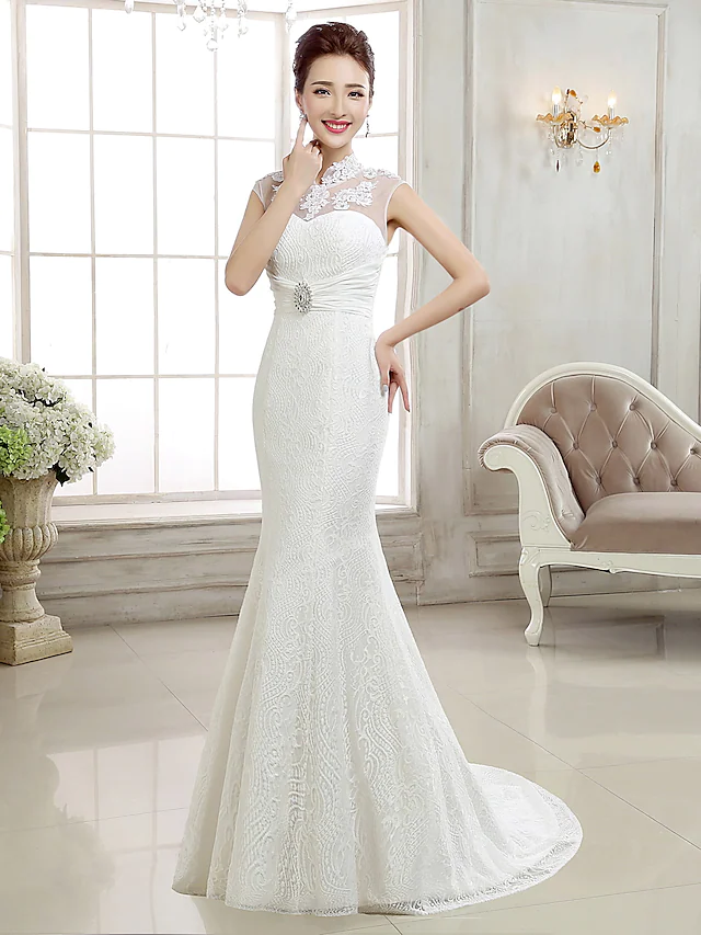 Full view of a bride wearing a high neck lace cap sleeve mermaid wedding dress.