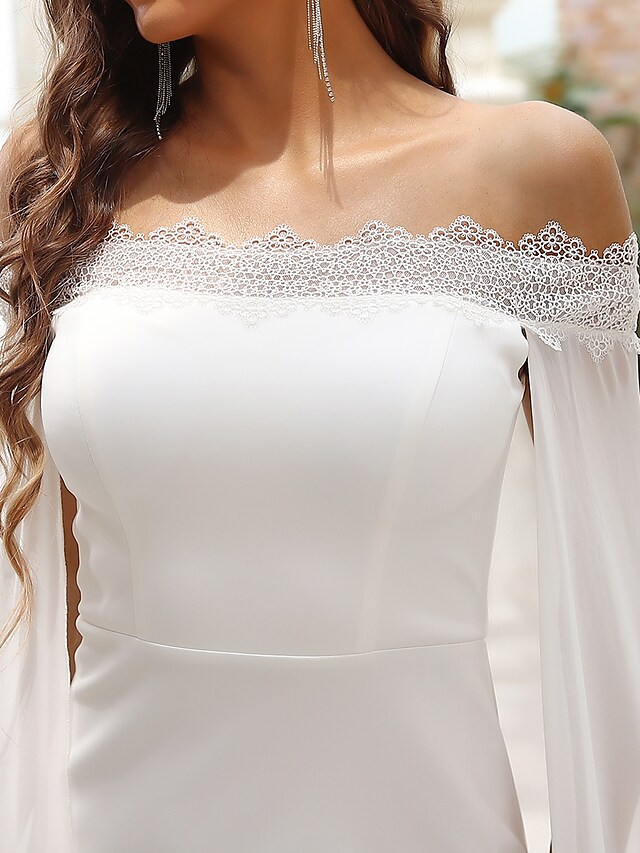 Full-length view of a white off-shoulder wedding dress with a mermaid silhouette.