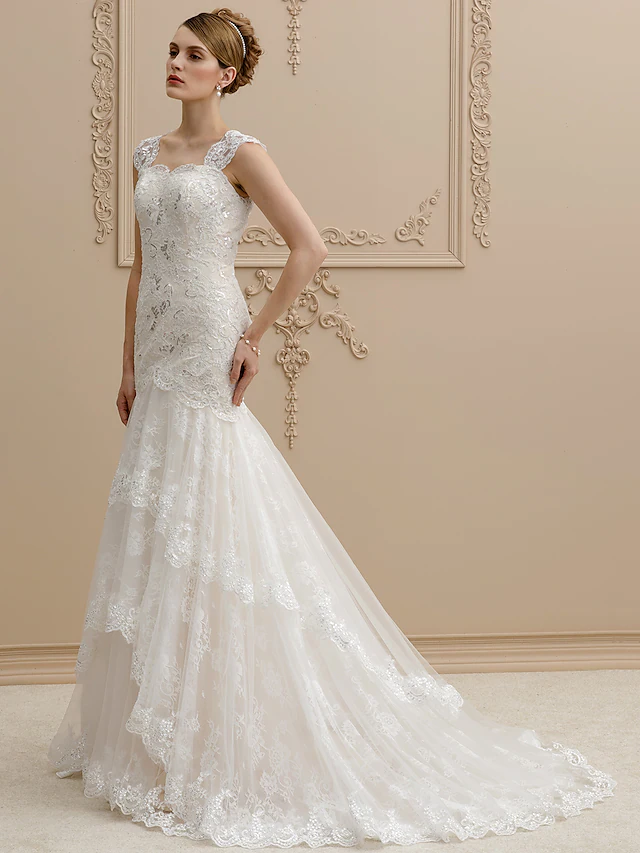 Close-up of the square neckline and delicate lace on a bridal gown.