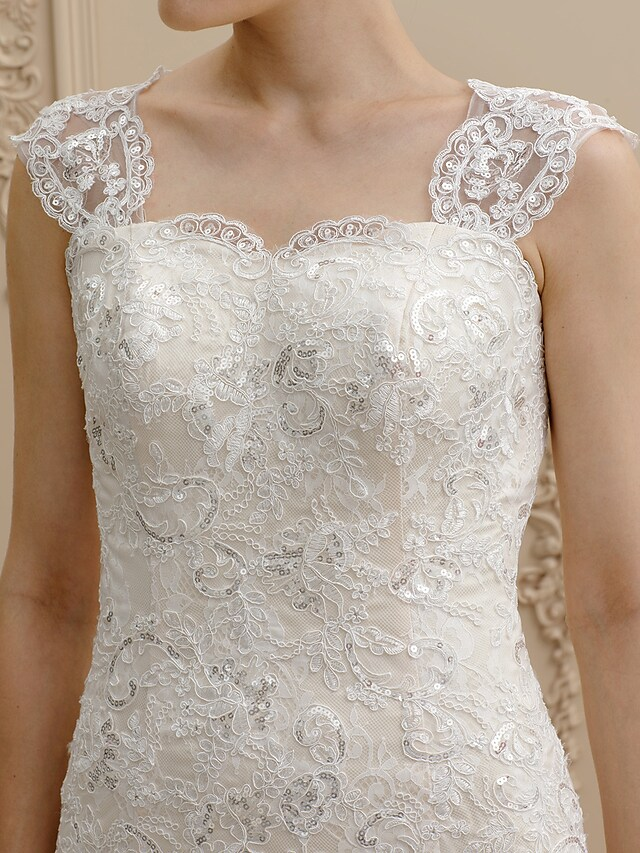 Detail of the intricate floral lace and sequin appliques on the wedding dress.