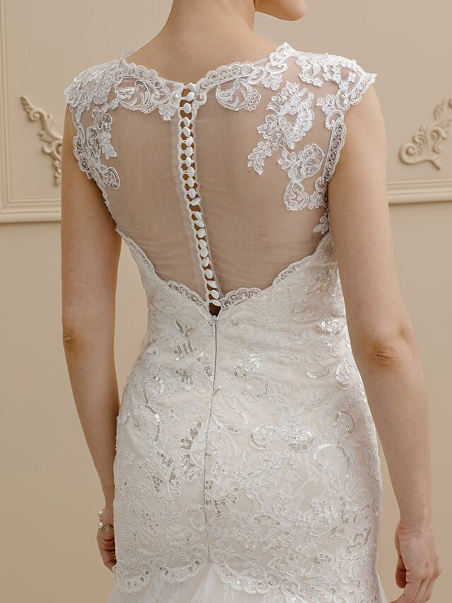 Bride posing in a mermaid wedding dress, highlighting the elegant silhouette.