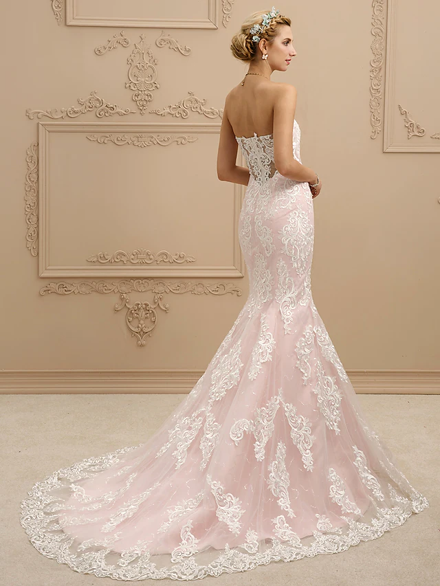 Side view of a sweetheart strapless mermaid wedding dress with lace details.