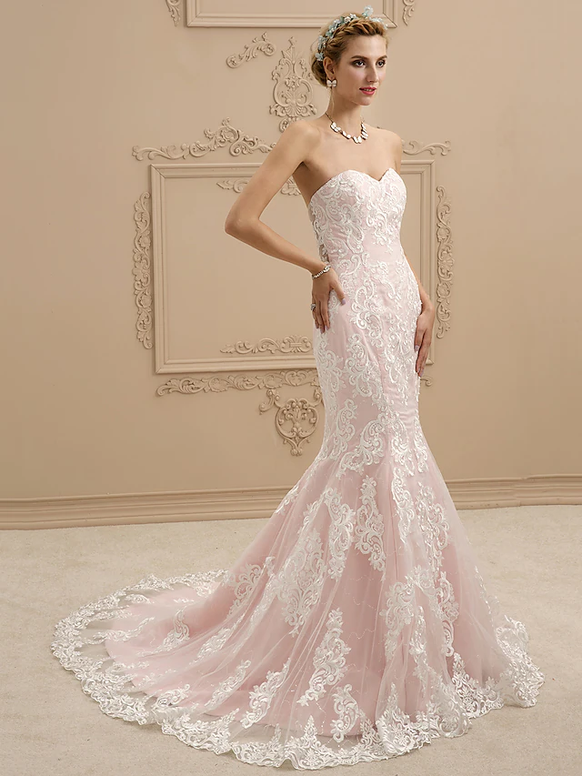Back view of a strapless wedding dress, highlighting the court train and lace appliques.